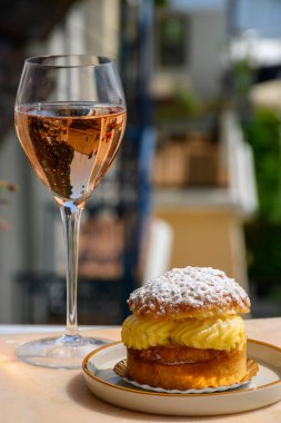 Fransız Rivierası 'nın şarap ve kekleri, bir bardak soğuk gül Cote de Provence şarabı ve Port Grimaud limanında Tarte Tropezienne keki, Fransa' nın Provence şehrinde yaz tatili