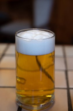 Taze demlenmiş hafif bira fıçıdan dökülen bira bardağıyla servis edilen bira fabrikasında Alman birasını deviriyor.