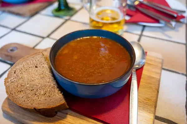 German food, thick, rich goulash meat soup served hot in bowl in old German cafe in countryside close up
