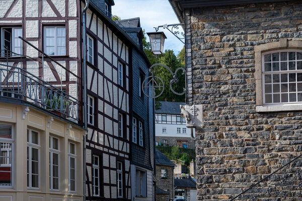 View of houses and streets of old colourful German town Monschau in bend of the river and hidden between the hills, Eifel national park, Germany in summer