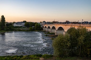 Fransa 'nın Loire nehri üzerindeki eski köprüde kraliyet kalesi ve manzaralı Amboise Ortaçağ kasabasında gün batımında yürümek