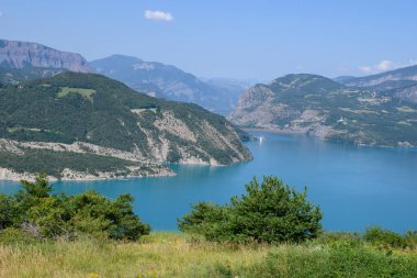 Serre-Poncon 'un mavi gölü, Hautes-Alpes ve Haute-de-Haute Provence departmanları arasındaki rezervuar sınırı, Batı Avrupa' nın en büyük departmanlarından biri.