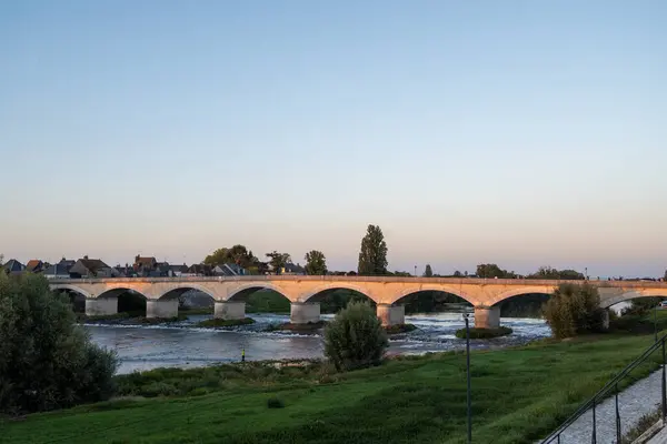 Fransa 'nın Loire nehri üzerindeki eski köprüde kraliyet kalesi ve manzaralı Amboise Ortaçağ kasabasında gün batımında yürümek