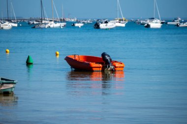 Güneşli bir günde Fransa 'nın Atlantik kıyı şeridi Bordeaux' nun güneybatısında Le Phare du Cap Ferret, Cap Ferret yarımadası yakınlarındaki birçok balıkçı teknesi ve istiridye çiftliğiyle Arcachon Körfezi 'ne bakın.