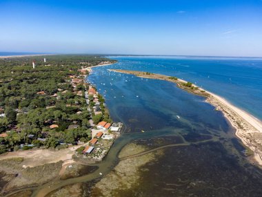 Arcachon Körfezi 'nde Le Phare du Cap Ferret ve Duna du Pilat yakınlarındaki balıkçı tekneleri ve istiridye çiftlikleri, Fransa' nın Bordeaux 'nun güneybatısındaki Cap Ferret yarımadası, güneşli bir günde Fransa' nın Atlantik kıyıları.