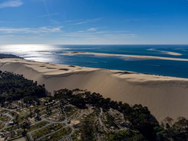 Güneşli bir günde Fransa 'nın Atlantik kıyı şeridi boyunca Bordeaux' nun güneybatısında Arcachon Körfezi bölgesindeki La Teste-de-Buch 'da yer alan Avrupa' nın en uzun kum tepeciğinin havadan görünüşü