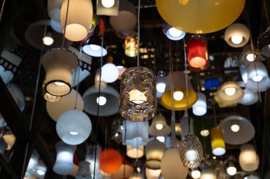 Karanlık odada lamba ve duvar aynası olan bir sürü farklı tavan lambası.