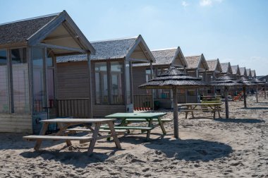 Plaj tatili ve kumsalda tatil, Katwijk-on-zee, Kuzey Denizi, Hollanda 'da deniz kıyısındaki ahşap kulübeler.