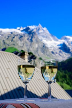 Savoy bölgesinden gelen beyaz Roussette de Savoie ve Vin de Savoie Fransız şarabı içerken yaz aylarında Hautes Alpes dağlarının zirvesinde kar manzaralı.