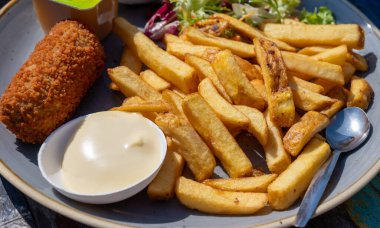 Hollanda fast food 'u, kıymalı kızartma ve patates cipsi ile doldurulmuş mayonez, yeşil salata, yakın çekim.