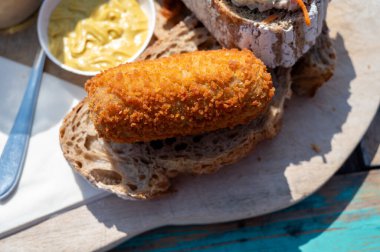 Hollanda fast food 'u, bol yağda kızartılmış köfte. Ekmeğe sığır eti konmuş, yakın çekim.