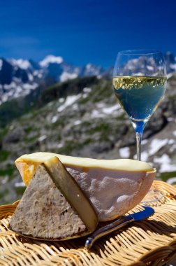 Peynir koleksiyonu, Fransız Alpleri 'ndeki Savoy bölgesinden Reblochon ve Tomme de Savoie peyniri, açık havada hafif inek sütü, Fransız Alpler dağlarının karlı tepelerinde manzara