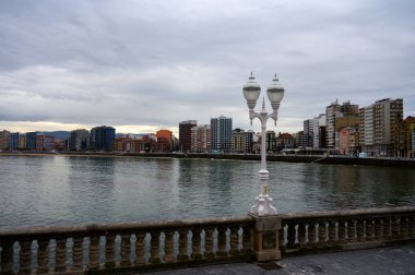 Gijon, Asturias, İspanya 'daki gezinti güvertesi, evler ve San Lorenzo plajına bakın.