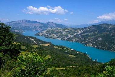 Serre-Poncon 'un mavi gölü üzerindeki hava manzarası, Hautes-Alpes ve Haute-de-Haute Provence departmanları arasındaki rezervuar sınırı, Batı Avrupa' nın en büyük bölümlerinden biri.