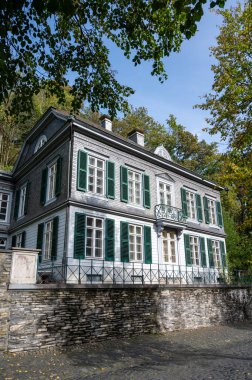 Nehrin kıvrımlarındaki eski renkli Alman şehri Monschau 'nun evleri ve caddeleri görünüyor ve tepelerin arasında saklanıyor, Eifel Ulusal Parkı, Almanya yazın.