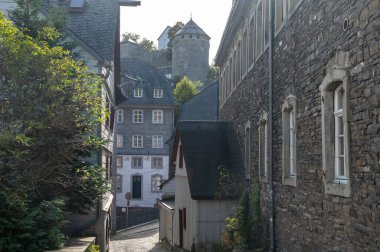 Nehrin kıvrımlarındaki eski renkli Alman şehri Monschau 'nun evleri ve caddeleri görünüyor ve tepelerin arasında saklanıyor, Eifel Ulusal Parkı, Almanya yazın.