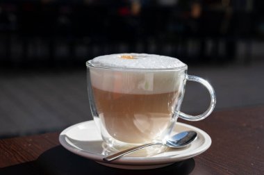 Açık kafede kremşantili sütlü taze İtalyan kahvesi içiyorum.