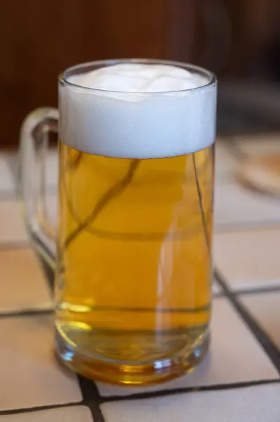 Freshly brewed light pils German beer in craft brewery served in beer glass poured from keg