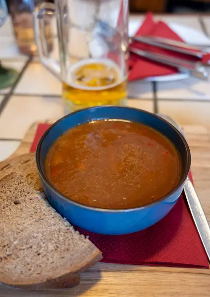German food, thick, rich goulash meat soup served hot in bowl in old German cafe in countryside close up