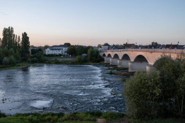 Fransa 'nın Loire nehri üzerindeki eski köprüde kraliyet kalesi ve manzaralı Amboise Ortaçağ kasabasında gün batımında yürümek