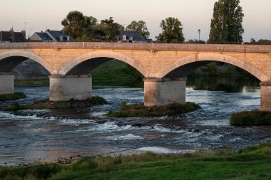 Fransa 'nın Loire nehri üzerindeki eski köprüde kraliyet kalesi ve manzaralı Amboise Ortaçağ kasabasında gün batımında yürümek