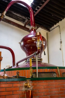 Charentias 'ta konyak ruhunun çifte damıtma işlemi. Bakır kaplar ve kazanlar hala eski içki imalathanesinde. Beyaz şarap bölgesi, Charente, Segonzac, Grand Champagne, Fransa