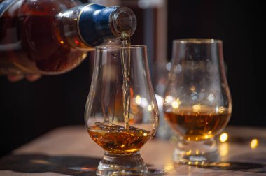Viski dökülüyor, bir bardak viski ve karışık viski Edinburgh, İskoçya 'daki barda servis ediliyor ve arka planda parti ışıkları var.