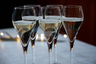Yeni yıl partisi, küçük brut şampanya baloncukları kava ya da lale gözlüklü şarap koyu arka planda çelenk ışıkları