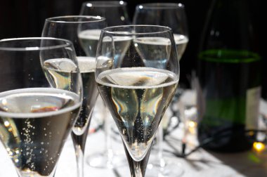 Yeni yıl partisi, küçük brut şampanya baloncukları kava ya da lale gözlüklü şarap koyu arka planda çelenk ışıkları