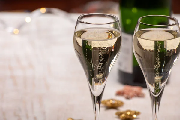 Glasses of bubble wine champagne, cremant, cava or prosecco and christmas stars for decoration close up