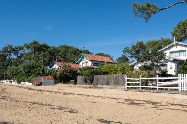 Arcachon Körfezi 'ndeki sahil evleri, çok sayıda balıkçı teknesi ve istiridye çiftliği, Kaptan Ferret yarımadası, Fransa, Bordeaux' nun güneybatısında Fransa 'nın Atlantik kıyı şeridi boyunca uzanan, tatil beldesi
