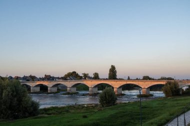 Fransa 'nın Loire nehri üzerindeki eski köprüde kraliyet kalesi ve manzaralı Amboise Ortaçağ kasabasında gün batımında yürümek