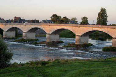 Fransa 'nın Loire nehri üzerindeki eski köprüde kraliyet kalesi ve manzaralı Amboise Ortaçağ kasabasında gün batımında yürümek
