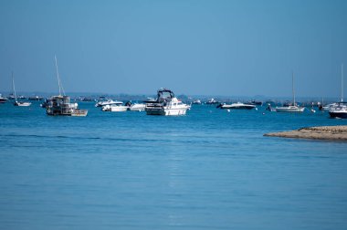 Güneşli bir günde Fransa 'nın Atlantik kıyı şeridi Bordeaux' nun güneybatısında Le Phare du Cap Ferret, Cap Ferret yarımadası yakınlarındaki birçok balıkçı teknesi ve istiridye çiftliğiyle Arcachon Körfezi 'ne bakın.