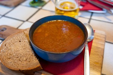 German food, thick, rich goulash meat soup served hot in bowl in old German cafe in countryside close up clipart