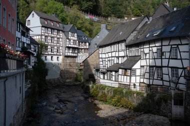 Nehrin kıvrımlarındaki eski renkli Alman şehri Monschau 'nun evleri ve caddeleri görünüyor ve tepelerin arasında saklanıyor, Eifel Ulusal Parkı, Almanya yazın.