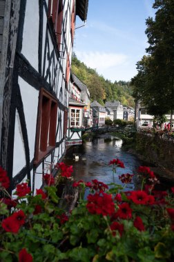 Nehrin kıvrımlarındaki eski renkli Alman şehri Monschau 'nun evleri ve caddeleri görünüyor ve tepelerin arasında saklanıyor, Eifel Ulusal Parkı, Almanya yazın.