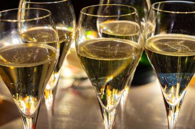 Yeni yıl partisi, küçük brut şampanya baloncukları kava ya da lale gözlüklü şarap koyu arka planda çelenk ışıkları