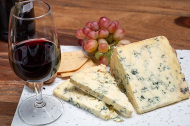 Kırmızı porto ve peynir eşleşmesi, olgunlaşmış mavi Stilton İngiliz peyniri ceviz ve cam yakut porto şarabı ile tatlı olarak servis edilir.