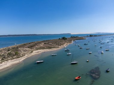 Güneşli bir günde Fransa 'nın Atlantik kıyıları Bordeaux' nun güneybatısında Le Phare du Cap Ferret, Cap Ferret yarımadası yakınlarındaki balıkçı tekneleri ve istiridye çiftlikleriyle Arcachon Körfezi 'ndeki hava manzarası.