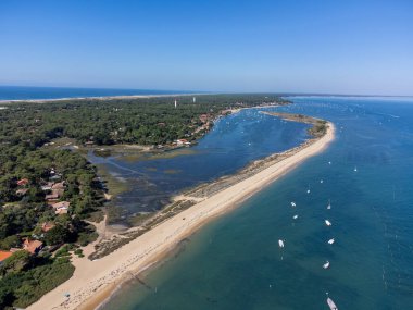 Arcachon Körfezi 'nde Le Phare du Cap Ferret ve Duna du Pilat yakınlarındaki balıkçı tekneleri ve istiridye çiftlikleri, Fransa' nın Bordeaux 'nun güneybatısındaki Cap Ferret yarımadası, güneşli bir günde Fransa' nın Atlantik kıyıları.