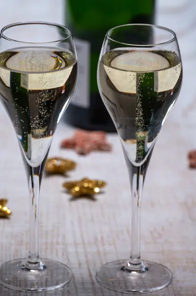Glasses of bubble wine champagne, cremant, cava or prosecco and christmas stars for decoration close up