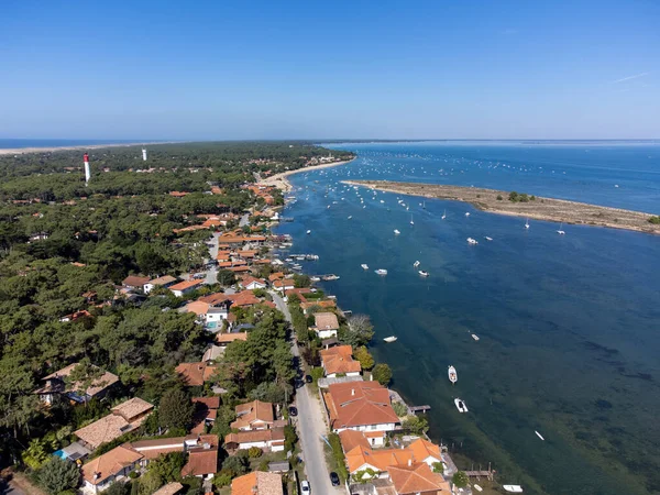 Arcachon Körfezi 'ndeki hava manzarası, pek çok balıkçı teknesi ve istiridye çiftliği, orman ve kırmızı deniz feneri Le Phare du Cap Ferret, Kaptan Ferret yarımadası, Fransa, Bordeaux' nun güneybatısı, Fransa 'nın Atlantik kıyı şeridi