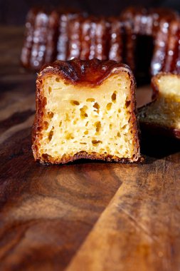 Canele, romlu ve vanilyalı Fransız pastası, yumuşak ve yumuşak muhallebi merkezi ve koyu, Bordeaux bölgesinin karamelize edilmiş kabuk spesiyali, Fransa kapat.