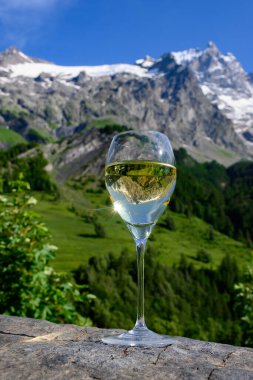 Savoy bölgesinden gelen beyaz Roussette de Savoie ve Vin de Savoie Fransız şarabı içerken yaz aylarında Hautes Alpes dağlarının zirvesinde kar manzaralı.
