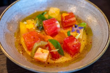 Renkli sağlıklı salata dilimlenmiş çiğ Fransız domatesleri taze keçi sütlü burrata peyniri ve salata sosuyla servis edilir.