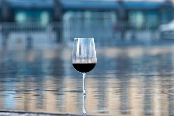 Tasting of Bordeaux blended red wine with wine city Bordeaux on  of Gironde Estuary, France. Glass of red French wine served outdoor.