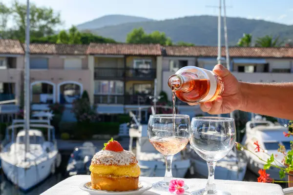 Fransız Rivierası 'nın şarap ve kekleri, bir bardak soğuk gül Cote de Provence şarabı ve Port Grimaud limanında Tarte Tropezienne keki, Fransa' nın Provence şehrinde yaz tatili