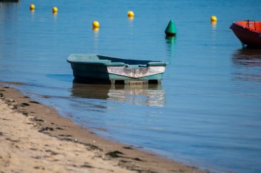 Güneşli bir günde Fransa 'nın Atlantik kıyı şeridi Bordeaux' nun güneybatısında Le Phare du Cap Ferret, Cap Ferret yarımadası yakınlarındaki birçok balıkçı teknesi ve istiridye çiftliğiyle Arcachon Körfezi 'ne bakın.