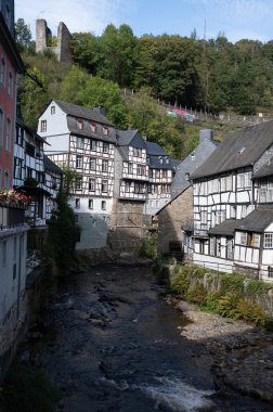 Nehrin kıvrımlarındaki eski renkli Alman şehri Monschau 'nun evleri ve caddeleri görünüyor ve tepelerin arasında saklanıyor, Eifel Ulusal Parkı, Almanya yazın.